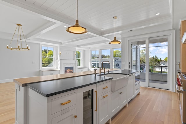 22 W Main St Unit 3, Groton, CT 06355 - kitchen featuring a lit fireplace, dark countertops, a sink, light wood finished floors, and open floor plan