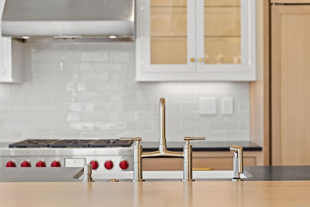 22 W Main St Unit 3, Groton, CT 06355 - kitchen featuring a sink, white cabinetry, tasteful backsplash, under cabinet range hood, and glass insert cabinets