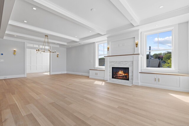 22 W Main St Unit 3, Groton, CT 06355 - unfurnished living room with light wood-style floors, a high end fireplace, beamed ceiling, and a notable chandelier