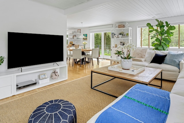 living area featuring wood ceiling, wood finished floors, and a healthy amount of sunlight