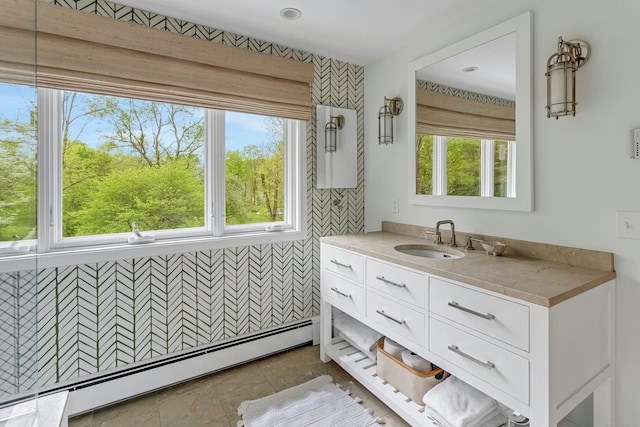 bathroom featuring vanity, a wealth of natural light, and a baseboard radiator