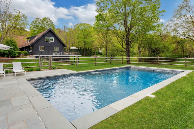 view of pool featuring a yard, fence, a fenced in pool, and a patio area