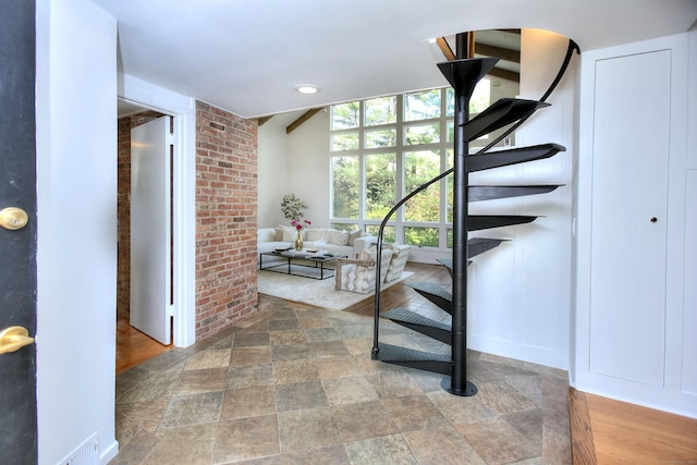 hallway with stairway and stone finish floors