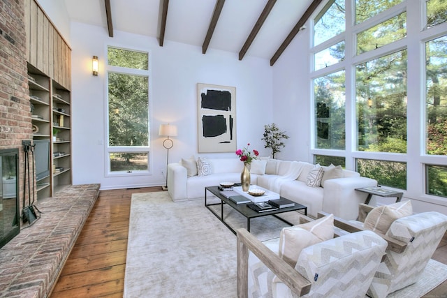 living area featuring wood-type flooring, healthy amount of natural light, and baseboards