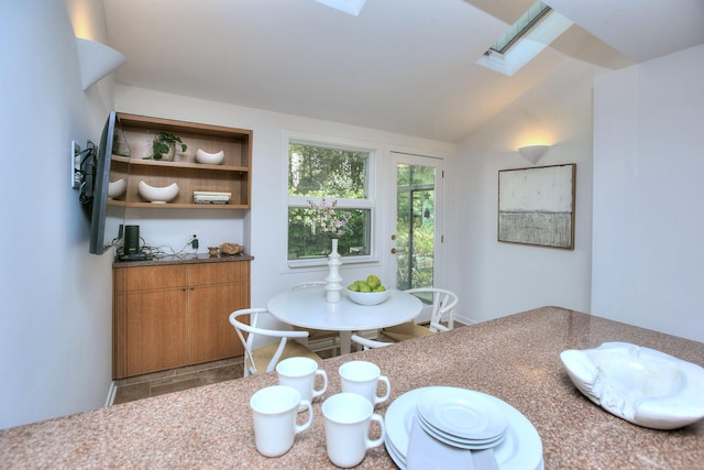 dining space featuring a skylight and vaulted ceiling