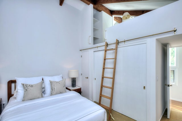 bedroom with light colored carpet and beam ceiling