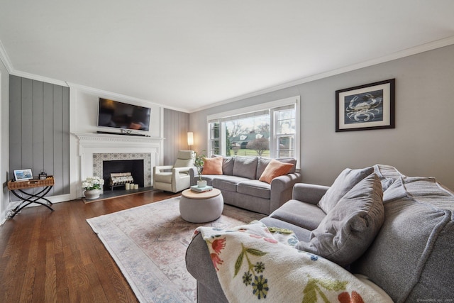 living room with dark wood-style flooring, ornamental molding, and a fireplace