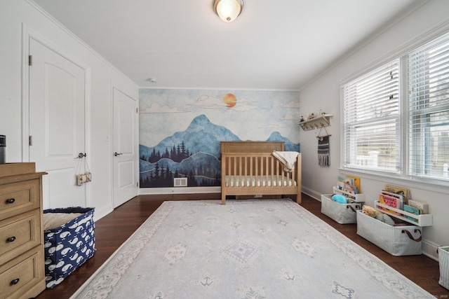 bedroom with ornamental molding, an accent wall, multiple windows, and dark wood-style floors