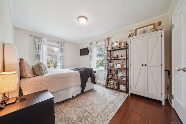 bedroom featuring dark wood finished floors and crown molding