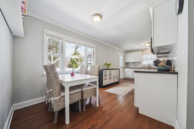 dining area featuring crown molding, baseboards, and dark wood-style flooring