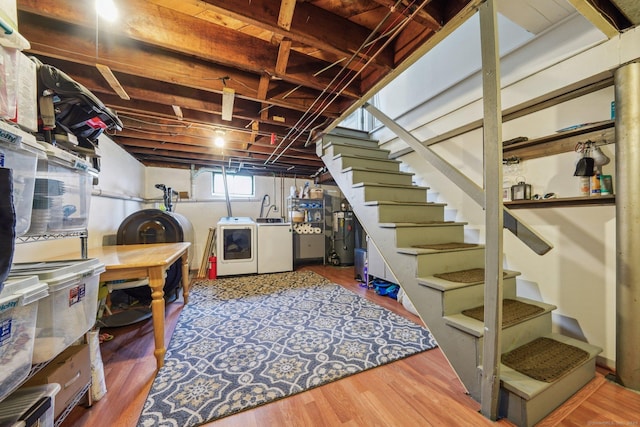 below grade area with separate washer and dryer, heating fuel, wood finished floors, and stairs