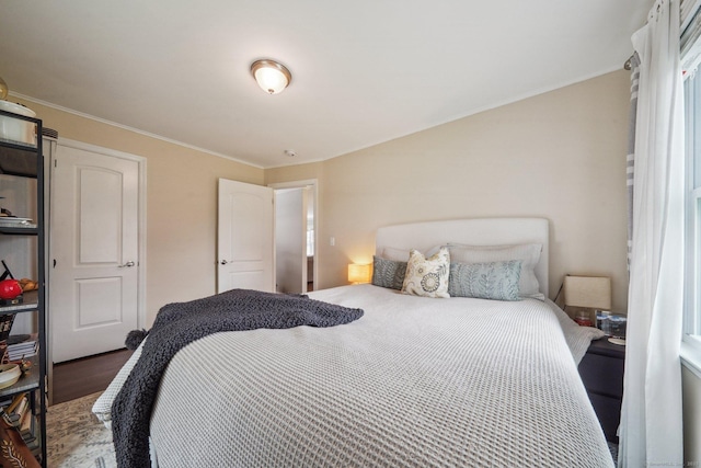 bedroom with wood finished floors and crown molding