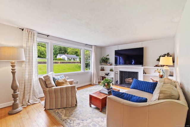 81 Beelzebub Rd, South Windsor, CT 06074 - living area featuring wood-type flooring, baseboards, and a brick fireplace