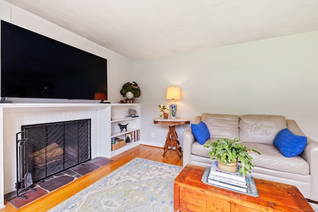 81 Beelzebub Rd, South Windsor, CT 06074 - living room featuring wood finished floors, a brick fireplace, and baseboards