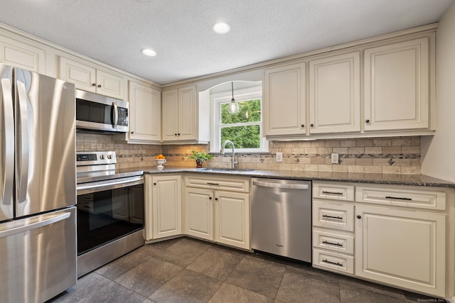 81 Beelzebub Rd, South Windsor, CT 06074 - kitchen with appliances with stainless steel finishes, a sink, cream cabinetry, tasteful backsplash, and dark stone countertops