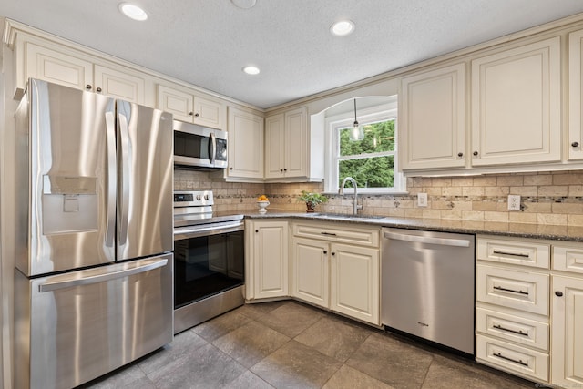 81 Beelzebub Rd, South Windsor, CT 06074 - kitchen with appliances with stainless steel finishes, a sink, cream cabinets, decorative backsplash, and recessed lighting
