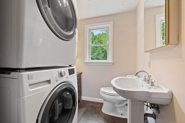 81 Beelzebub Rd, South Windsor, CT 06074 - laundry area with stacked washer / drying machine, baseboards, and dark stone finish flooring
