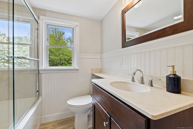 81 Beelzebub Rd, South Windsor, CT 06074 - bathroom featuring vanity, wood finished floors, toilet, wainscoting, and enclosed tub / shower combo