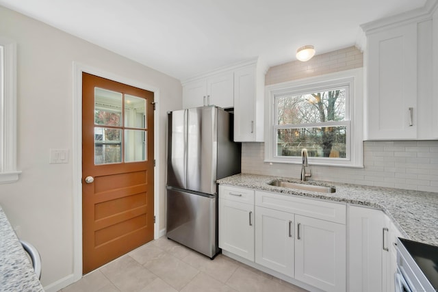 17 Lydall Rd, East Hartford, CT 06111 - kitchen featuring freestanding refrigerator, a sink, decorative backsplash, and light tile patterned floors