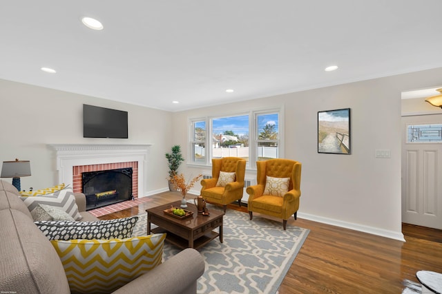 17 Lydall Rd, East Hartford, CT 06111 - living room featuring wood finished floors, baseboards, recessed lighting, ornamental molding, and a brick fireplace