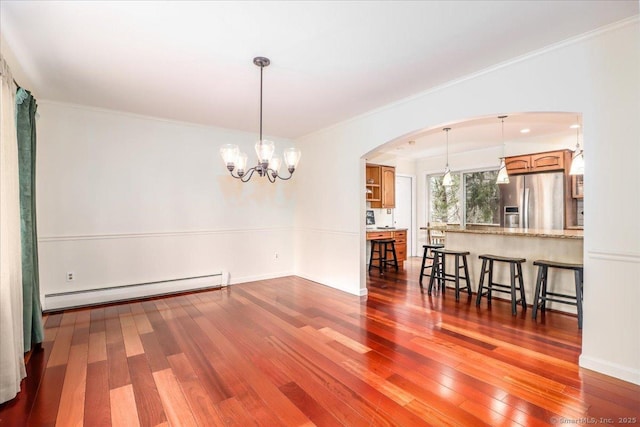 dining space with a baseboard heating unit, arched walkways, hardwood / wood-style floors, and an inviting chandelier