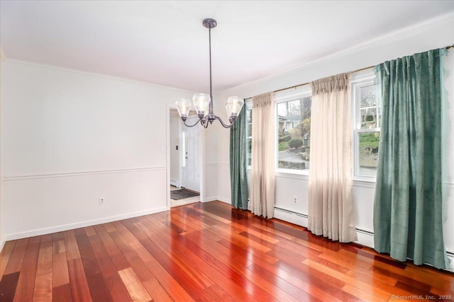 unfurnished dining area with baseboards, an inviting chandelier, baseboard heating, hardwood / wood-style floors, and ornamental molding