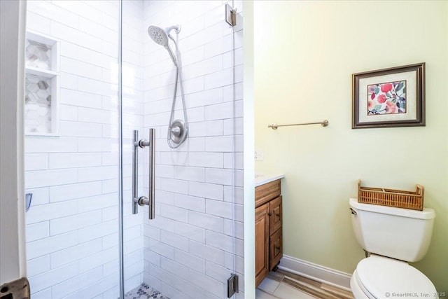 full bathroom with baseboards, toilet, vanity, and a stall shower