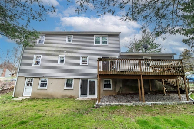 rear view of house featuring a lawn and a deck