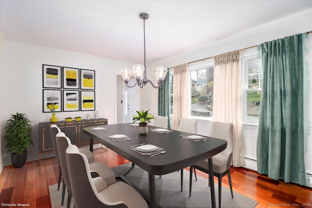 dining room with wood finished floors, a notable chandelier, and crown molding