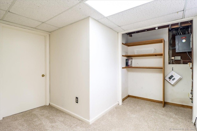 finished basement featuring baseboards, carpet floors, electric panel, and a paneled ceiling