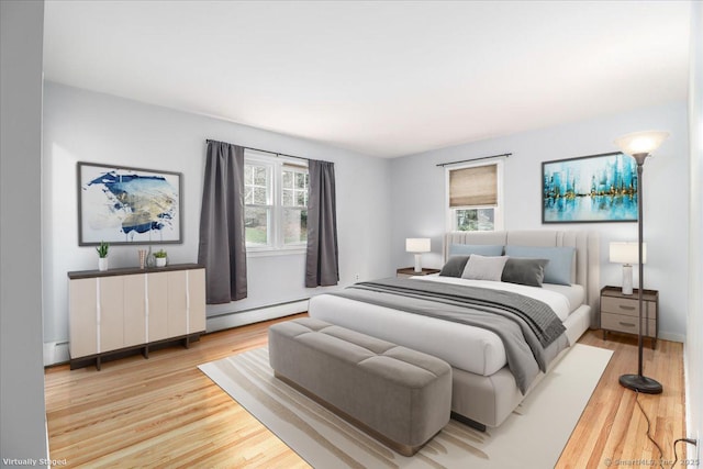 bedroom featuring wood finished floors, baseboard heating, and a baseboard heating unit