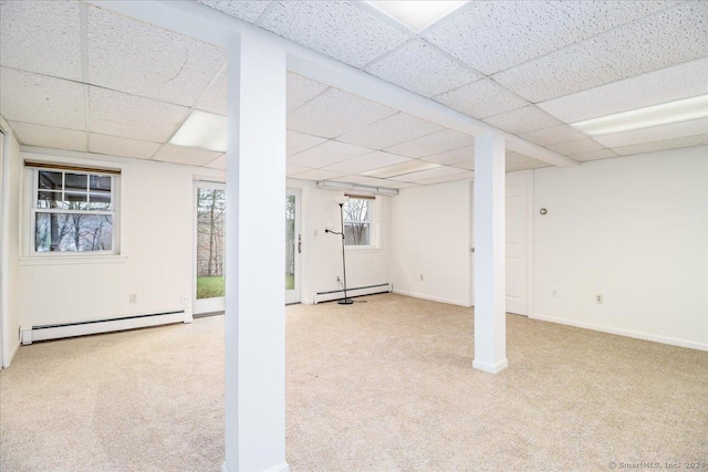 below grade area featuring a baseboard radiator, a paneled ceiling, and carpet floors