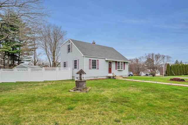 view of front of property featuring fence, roof with shingles, a chimney, and a front yard