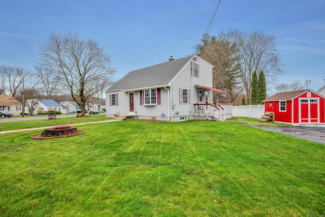view of front of property with a front lawn, an outbuilding, a shed, a chimney, and fence