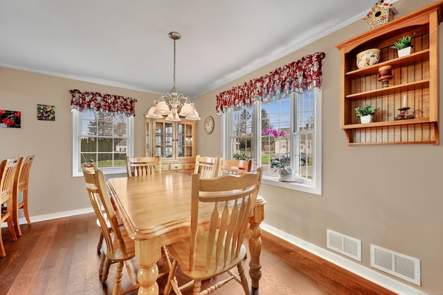 dining space featuring an inviting chandelier, visible vents, baseboards, and dark wood-type flooring