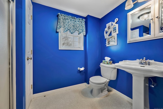half bathroom with baseboards and toilet