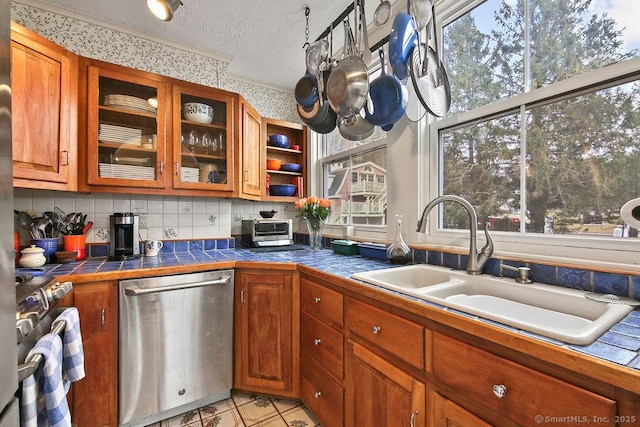 77 Main St, East Haddam, CT 06423 - kitchen with appliances with stainless steel finishes, a sink, tile countertops, a textured ceiling, and brown cabinetry