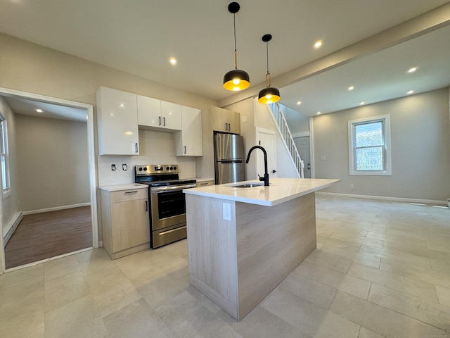 kitchen with an island with sink, modern cabinets, appliances with stainless steel finishes, light countertops, and a sink