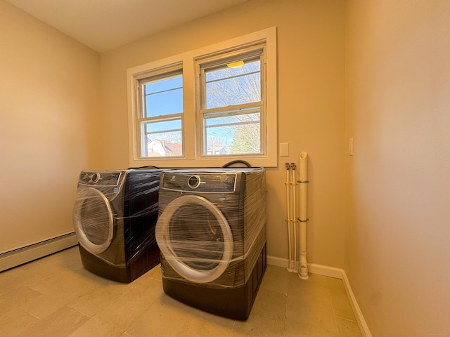 washroom with a baseboard heating unit, washing machine and dryer, laundry area, and baseboards