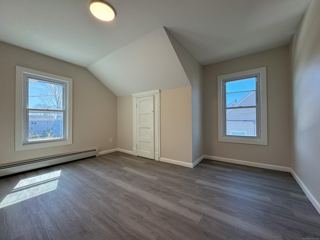 bonus room featuring dark wood-style flooring, baseboards, and plenty of natural light