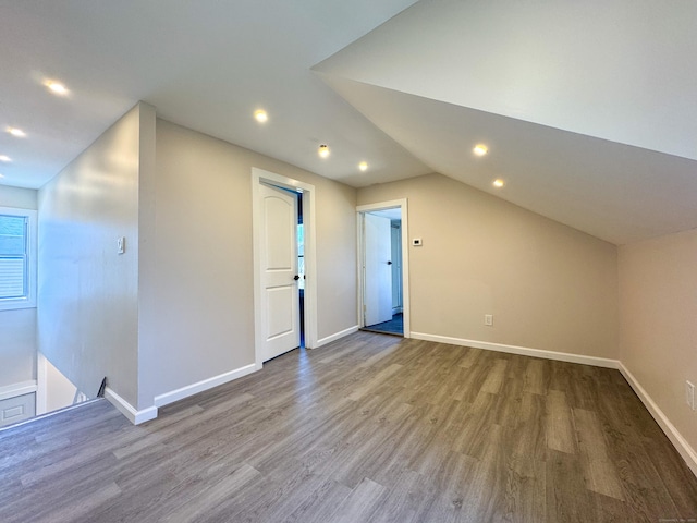 bonus room with wood finished floors, baseboards, lofted ceiling, and recessed lighting