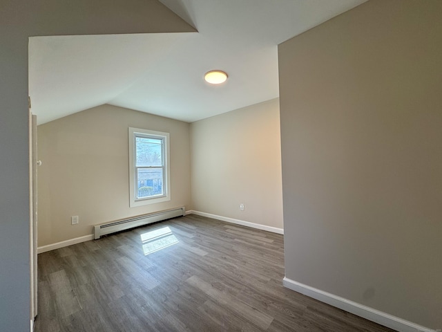 additional living space with baseboard heating, dark wood finished floors, baseboards, and lofted ceiling