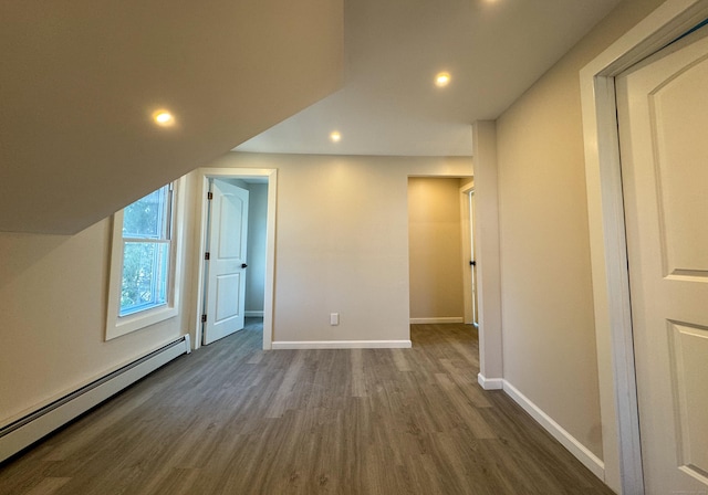 bonus room featuring a baseboard heating unit, baseboards, dark wood-type flooring, and recessed lighting