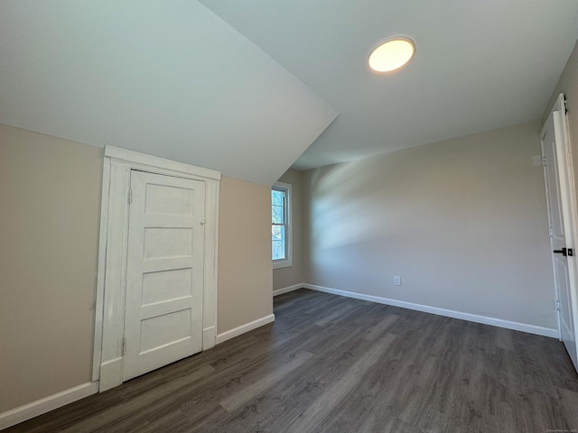 bonus room featuring baseboards and dark wood-style flooring