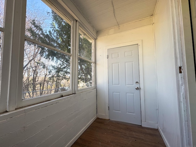 doorway with wood finished floors and baseboards