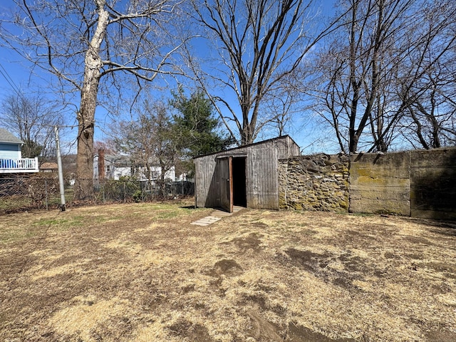 view of yard with fence, an outbuilding, and a storage unit