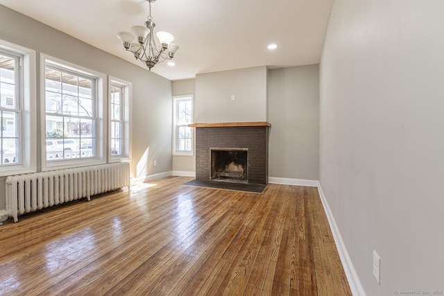 67-69 Sterling St, Hartford, CT 06154 - unfurnished living room with radiator, a fireplace, a chandelier, hardwood / wood-style floors, and baseboards