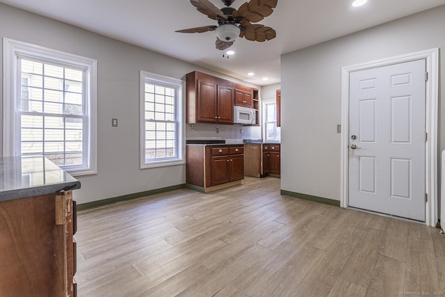 67-69 Sterling St, Hartford, CT 06154 - kitchen featuring tasteful backsplash, white microwave, light wood-style flooring, and ceiling fan