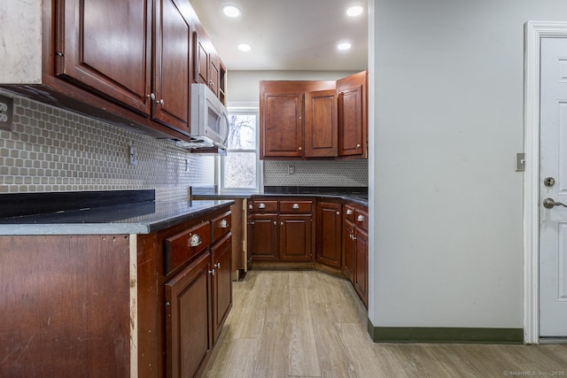 67-69 Sterling St, Hartford, CT 06154 - kitchen with white microwave, dark countertops, backsplash, and light wood-style floors