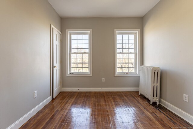 67-69 Sterling St, Hartford, CT 06154 - empty room featuring radiator heating unit, a wealth of natural light, baseboards, and dark wood-style floors